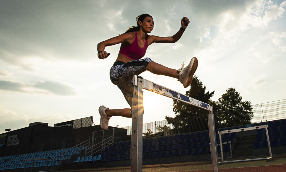 woman jumping hurdle